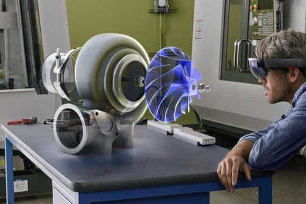 Engineer using enterprise augmented reality headset to view a digital prototype